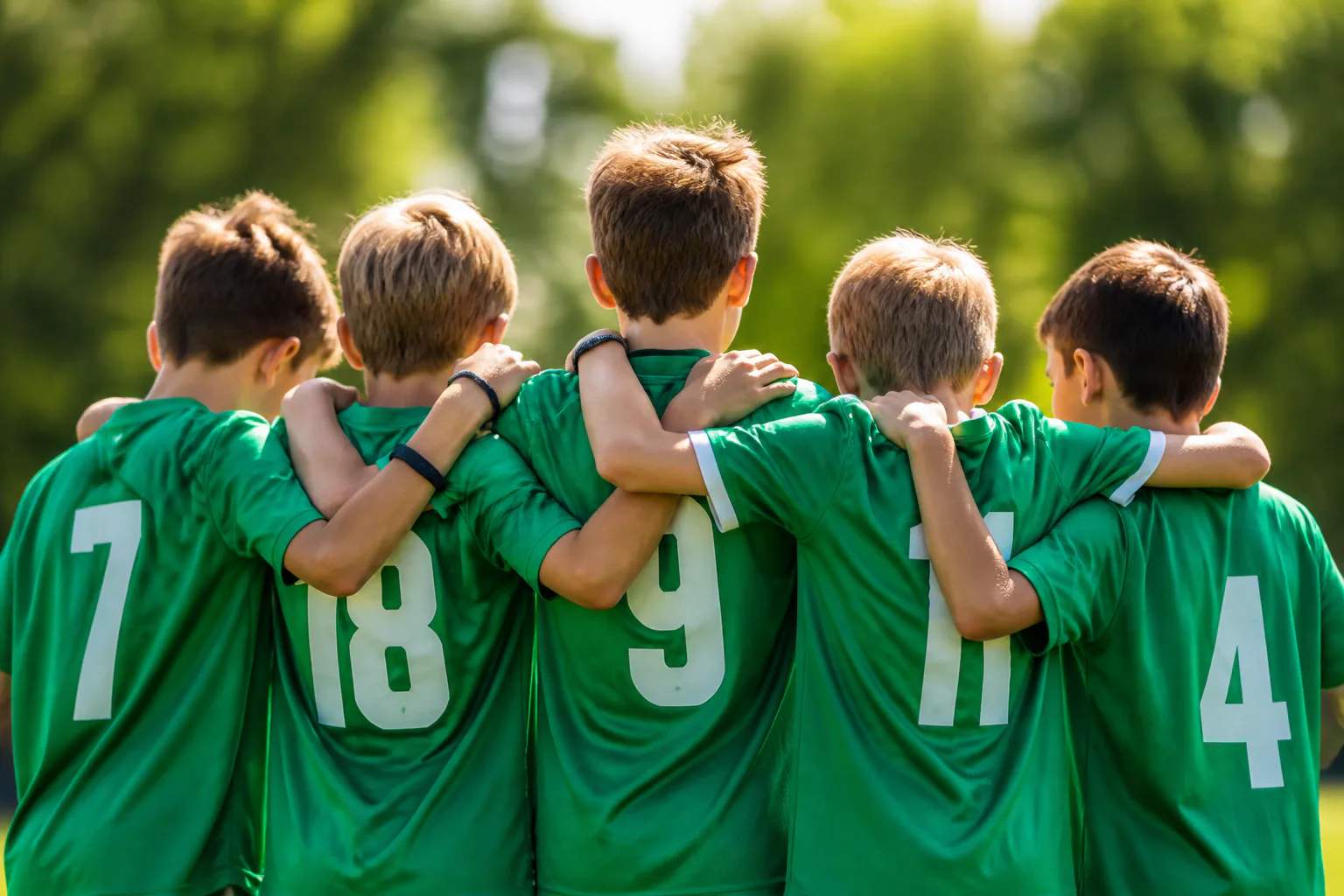 Youth soccer team huddle outdoors
